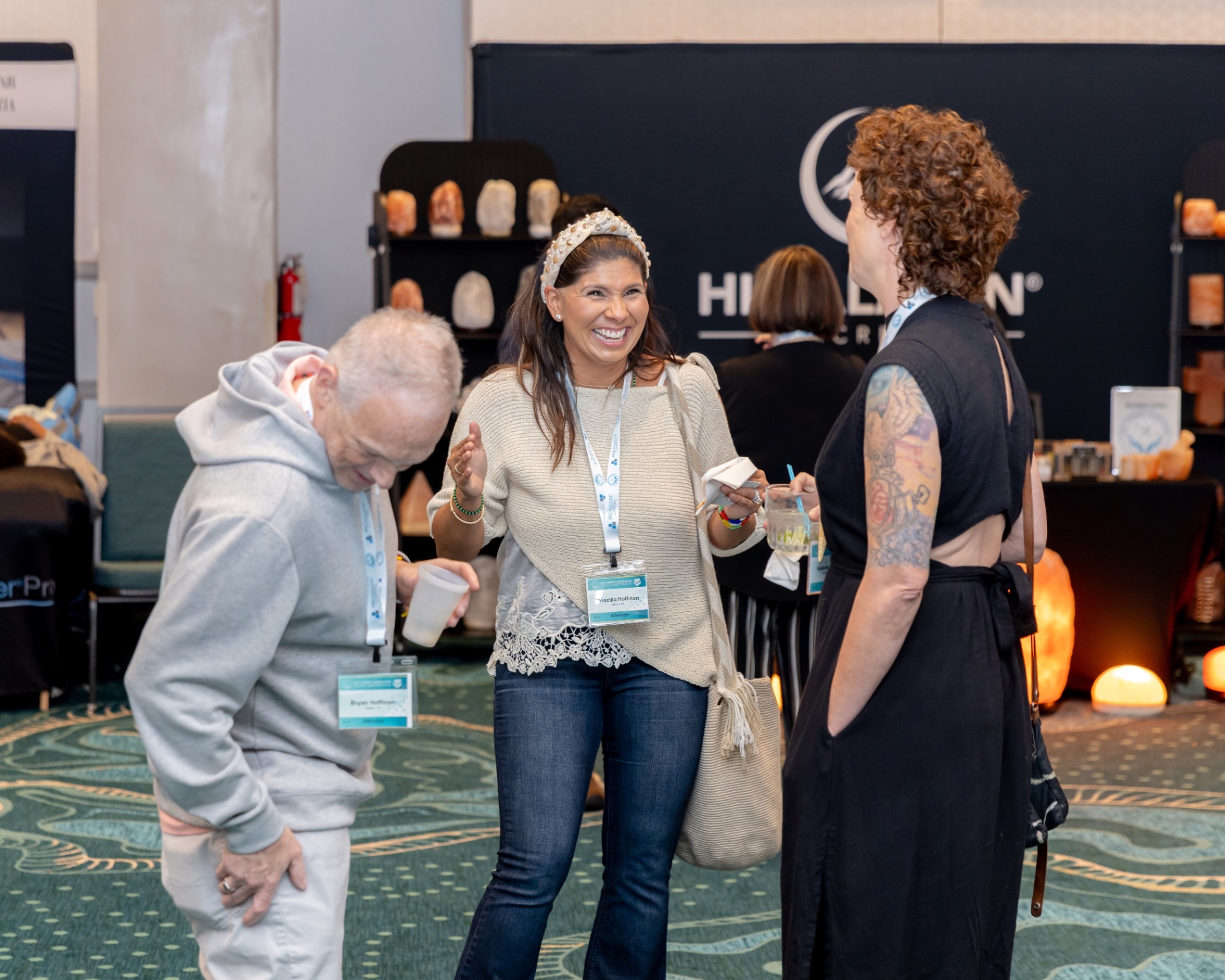 Attendees laughing in front of the Himalayan Secrets booth.