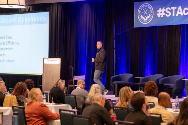 Speaker pacing the breakout stage discussing growth constraints.