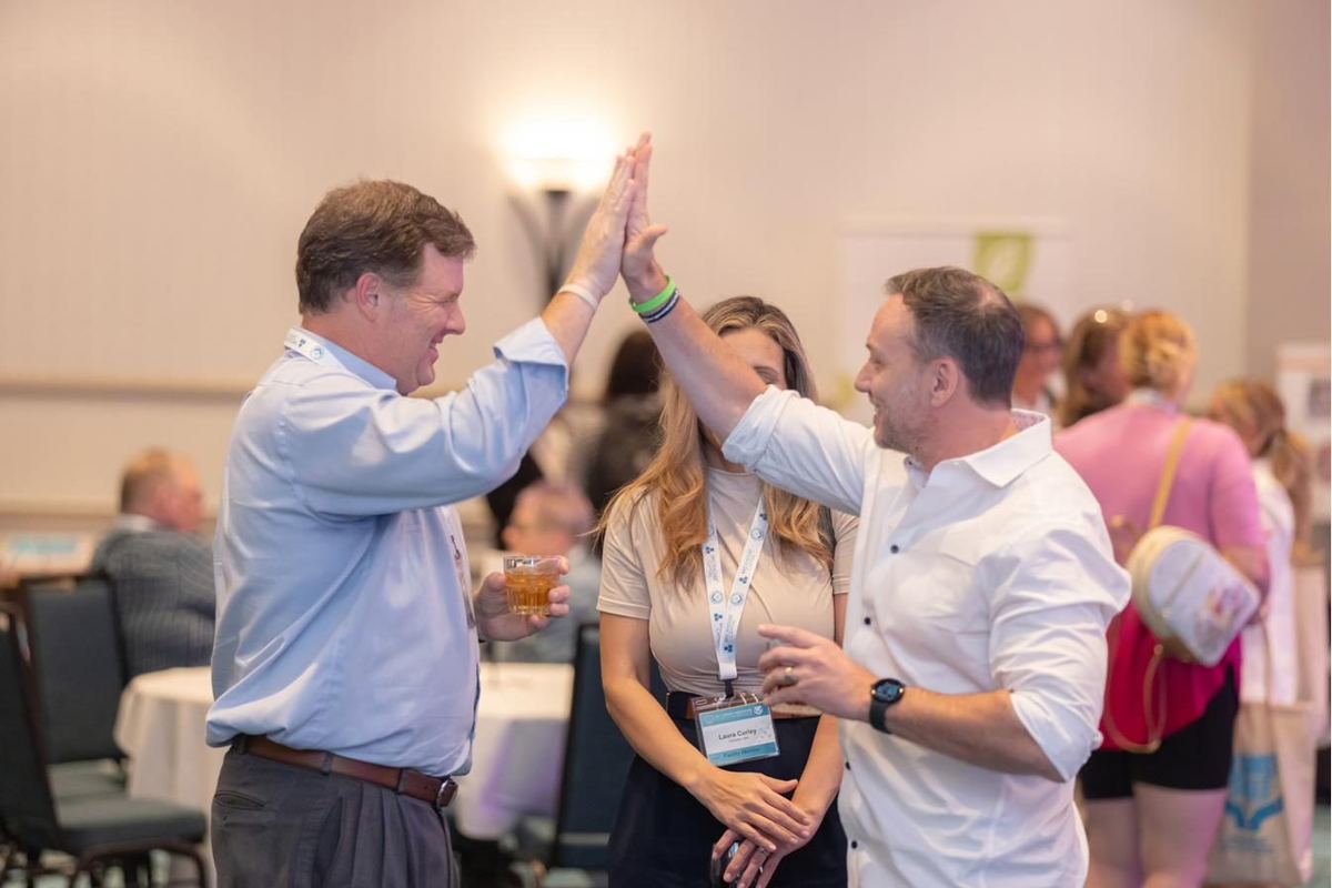 Members high-fiving and celebrating at an STA event.