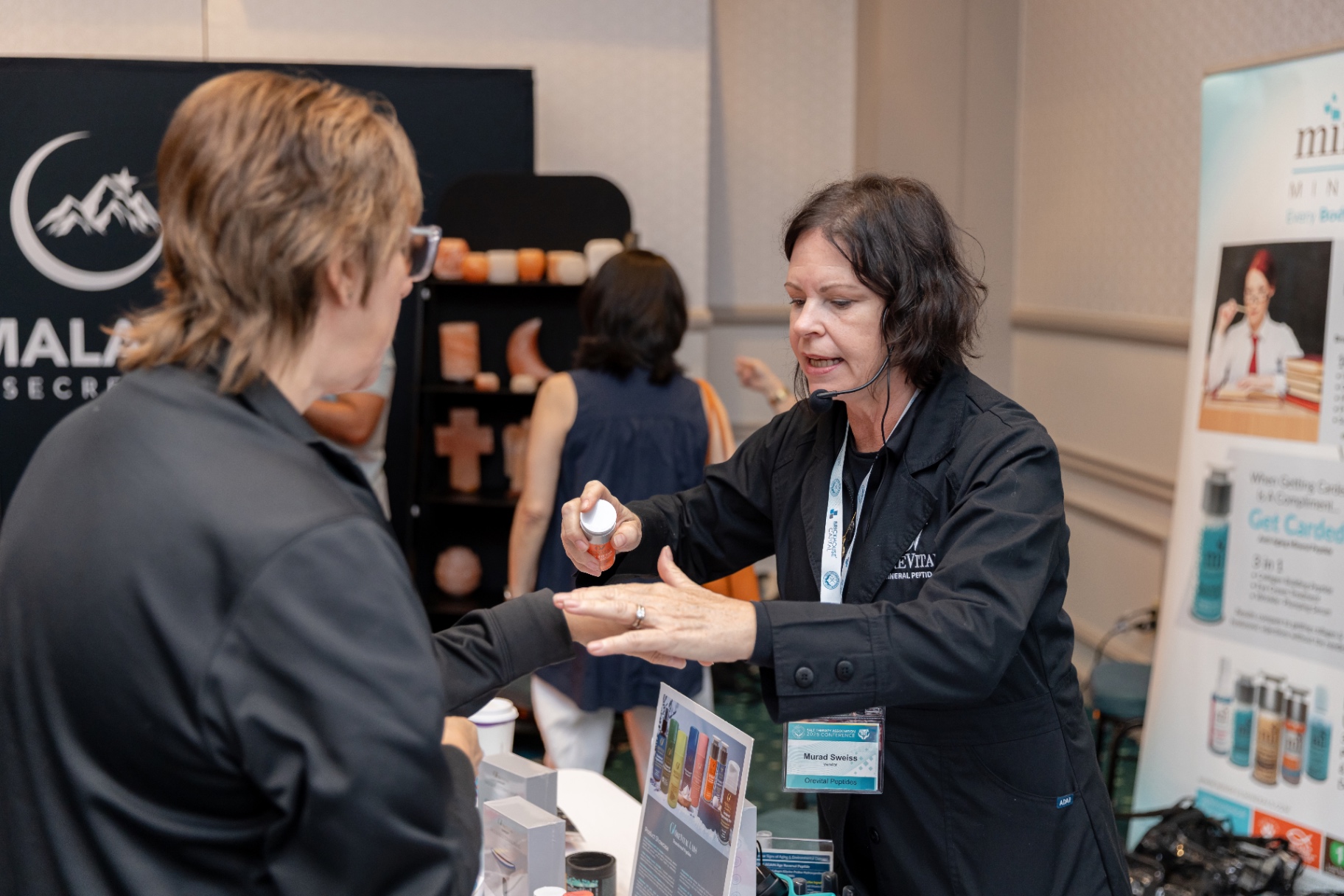 Orevital Peptides rep demonstrating product to an attendee.