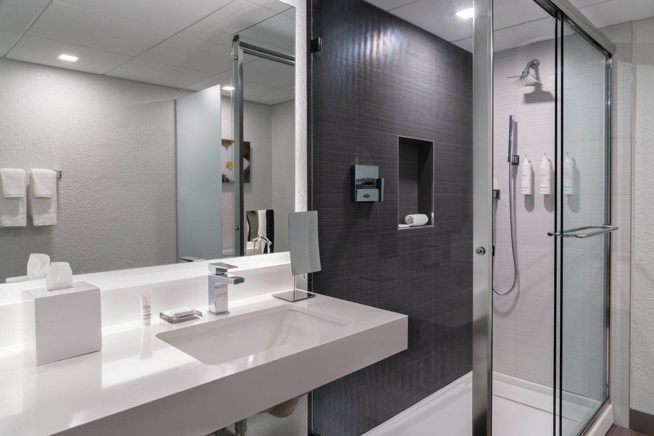 Renovated guest bathroom with dark tile accents.