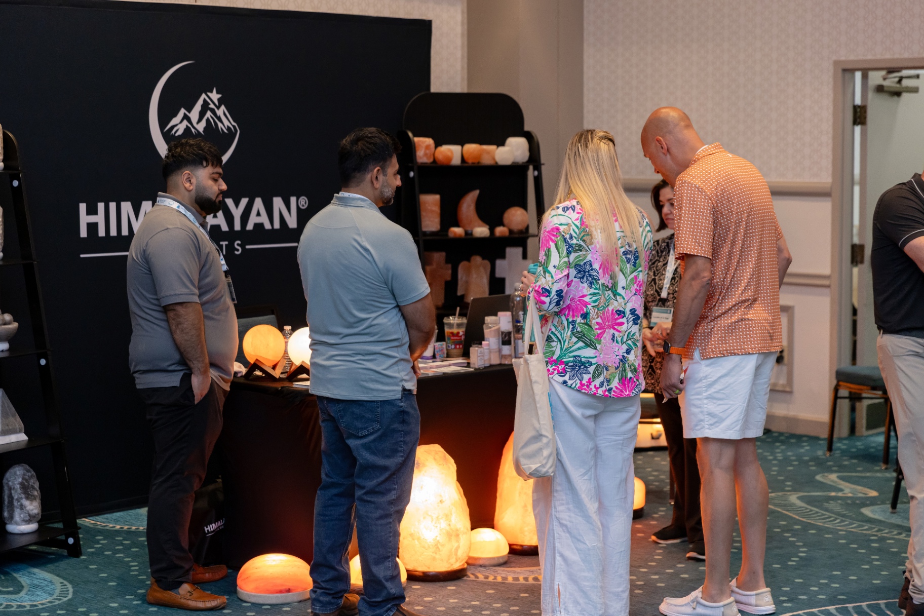 Attendees browsing the Himalayan Salts booth with lit salt lamps.