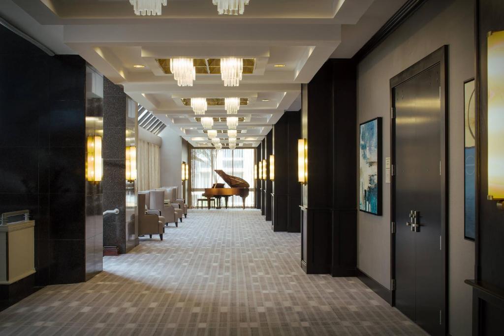 Elegant corridor inside the Miami Marriott Dadeland with chandeliers and lounge seating.