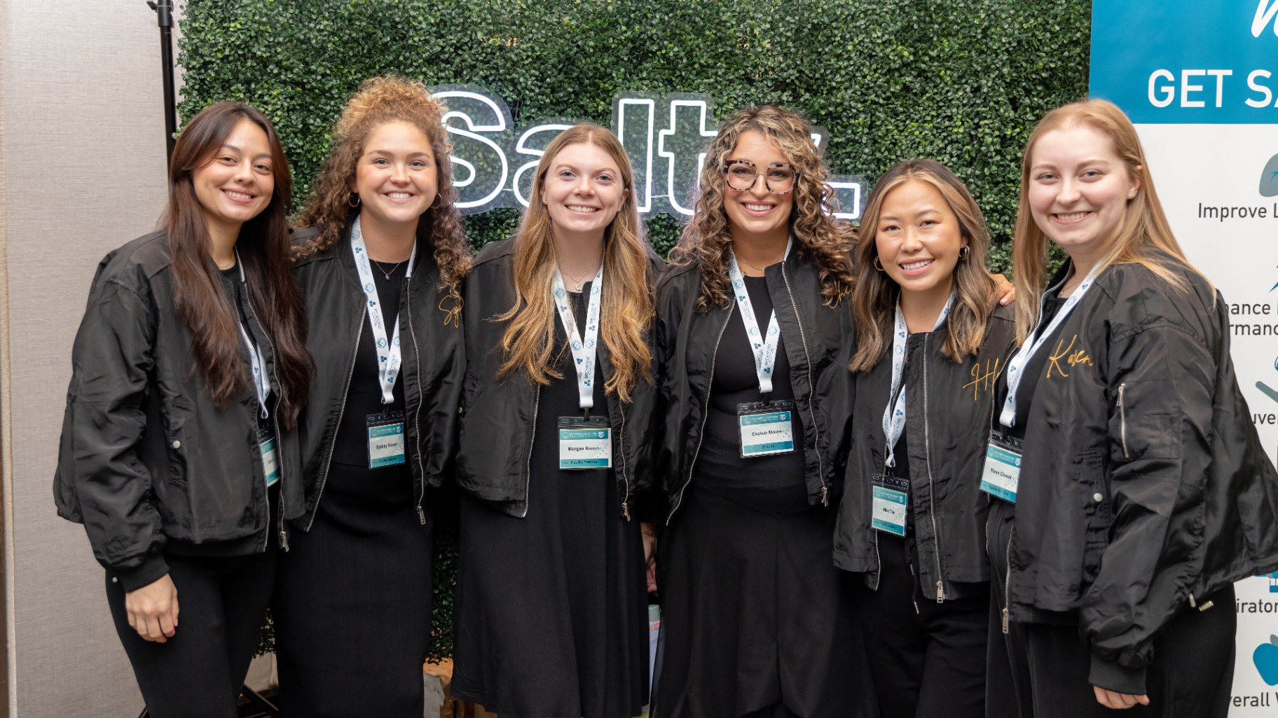Group of women in matching black Salty bomber jackets at STACon.