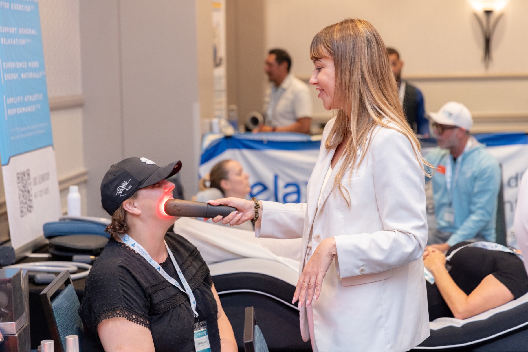 Vendor giving a red light therapy demo to an attendee.